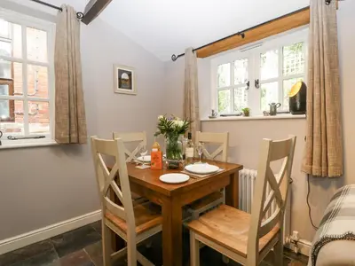 a dining room with a wooden table and chairs at The Old Bakehouse in Leominster
