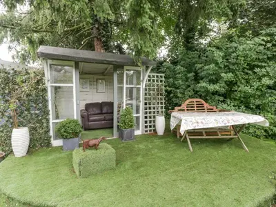a small garden with a table and a bench at The Old Bakehouse in Leominster