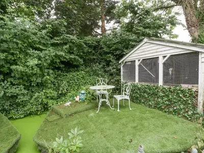 a small garden with a table and chairs in the grass at The Old Bakehouse in Leominster