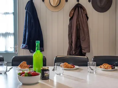 a table with plates of food and a bottle of wine at 3 Bed in Hay-on-Wye 83593 in Hay-on-Wye