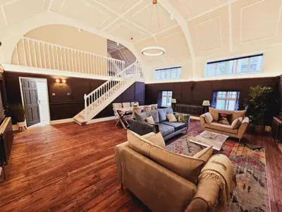 a large living room with couches and a staircase at Unique town centre apartment with vaulted ceiling - Pass the Keys in Shrewsbury