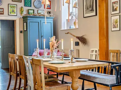 a dining room with a wooden table with candles on it at 4 Bed in Hereford oc-80464 in Glasbury