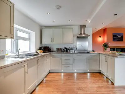a kitchen with white cabinets and a wooden floor at 2 Bed in Llangammarch Wells oc-bn059 in Garth