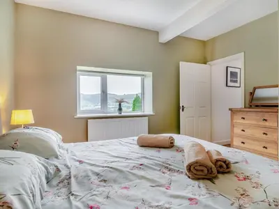 a bedroom with a large bed with towels on it at 2 Bed in Llangammarch Wells oc-bn059 in Garth
