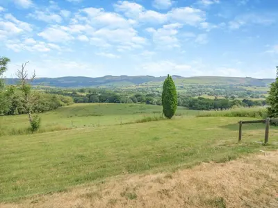 a green field with a tree in the distance at 2 Bed in Llangammarch Wells oc-bn059 in Garth