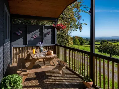 a wooden deck with a picnic table on a balcony at 3 Bed in Clyro BN141 in Clyro