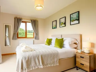 a bedroom with a large bed with green pillows at 2 Bed in Llandrindod Wells oc-89063 in Nantmel
