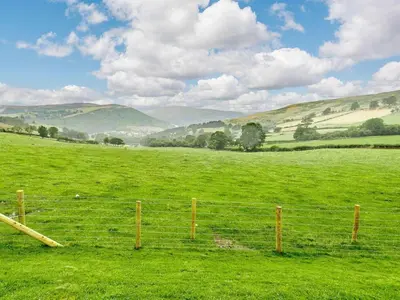 a fence in the middle of a green field at 2 Bed in Llandrindod Wells oc-89063 in Nantmel