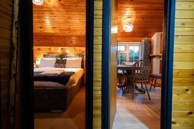 a bedroom with a bed in a wooden house at Rural Log Cabin in Snowdonia near Coed y Brenin by Seren Short Stays in Ffestiniog
