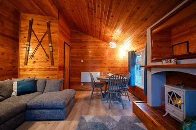 a living room with a couch and a table at Rural Log Cabin in Snowdonia near Coed y Brenin by Seren Short Stays in Ffestiniog