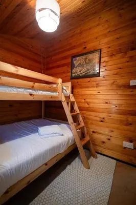 a bedroom with two bunk beds in a log cabin at Rural Log Cabin in Snowdonia near Coed y Brenin by Seren Short Stays in Ffestiniog