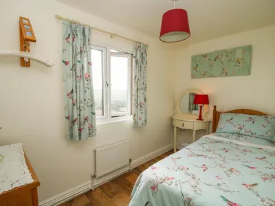 a bedroom with a bed and a window at Dragonfly Lodge in Shrewsbury