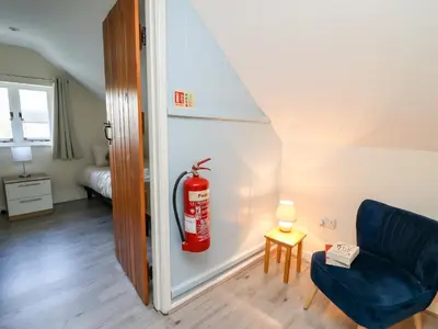 a living room with a fire extinguisher on the wall at Railway Station Cottage in Llandrindod Wells