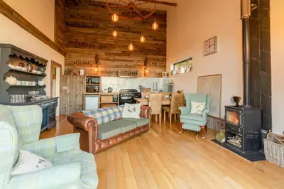 a living room with a couch and a table at Outshot Barn in Hay-on-Wye