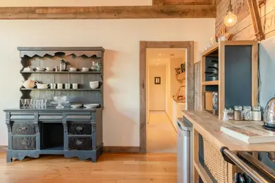 a kitchen with a blue island in a room at Outshot Barn in Hay-on-Wye