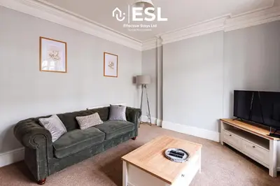 a living room with a couch and a tv at 4 Bedroom House. Close to Shrewsbury Town Centre in Shrewsbury