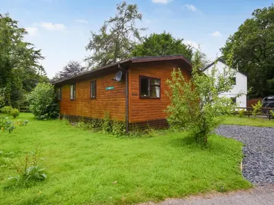 a log cabin in a yard with a grassy yard at The Beehive C29 - Uk45926 in Newtown