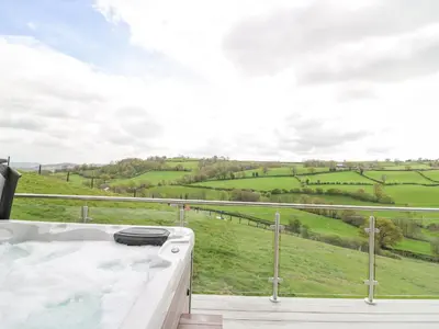 a bath tub with a view of a green field at Barcud Coch - Red Kite in Welshpool