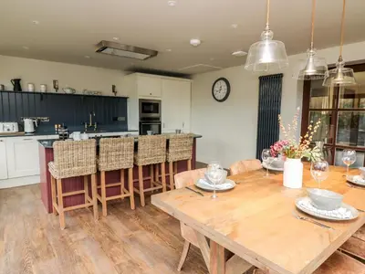 a kitchen and dining room with a wooden table at Dant Y Llew in Bow Street