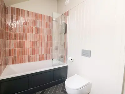 a bathroom with a tub and a toilet and a sink at Dant Y Llew in Bow Street