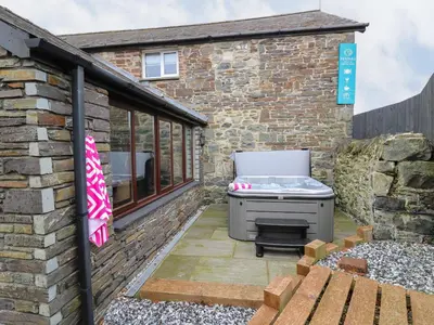a barbecue on a patio next to a brick building at Dant Y Llew in Bow Street