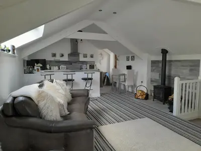 a living room with a couch and a kitchen at The Old Fire Station in Tregaron