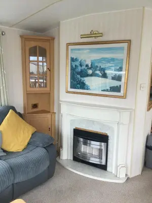 a living room with a fireplace with a painting above it at H2 in Aberystwyth