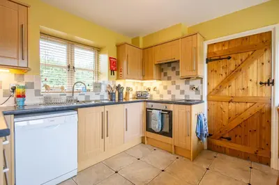 a kitchen with wooden cabinets and a dishwasher at Waun Yscir Rural escape in the Brecon Beacons in Brecon