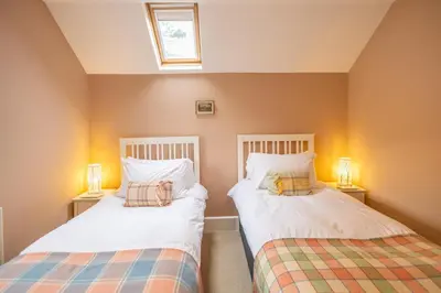 two beds in a small room with two lamps at Waun Yscir Rural escape in the Brecon Beacons in Brecon