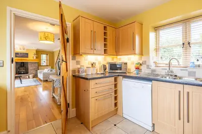 a kitchen with yellow walls and wooden cabinets at Waun Yscir Rural escape in the Brecon Beacons in Brecon