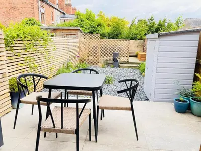 a patio with a table and chairs in a backyard at Benyon Street Townhouse in Shrewsbury