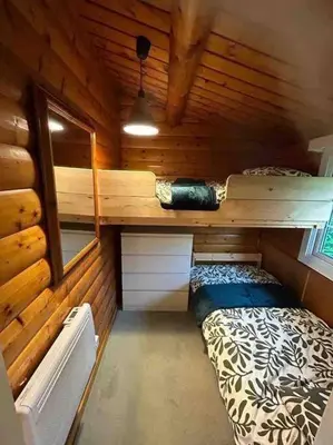 a small room with a bed in a wooden cabin at Snug and cosy log cabin. in Trawsfynydd
