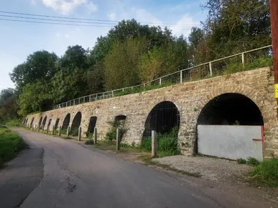 a stone bridge with arches on the side of a road at Rhif Deg in Brecon