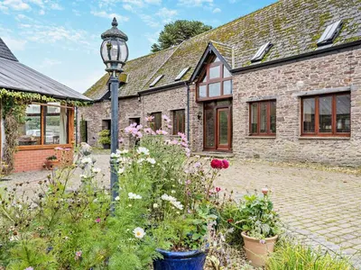 a brick house with a street light and flowers at 3 Bed in Brecon oc-bn430 in Llangorse