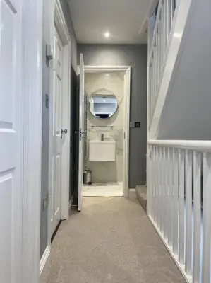 a hallway with a bathroom with a sink at Isfryn, holiday home in Aberdyfi in Aberdyfi
