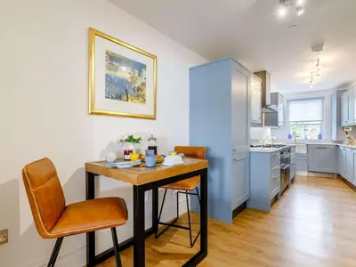 a kitchen with a table and chairs in a room at The Penthouse Westhaven Aberdyfi in Aberdyfi