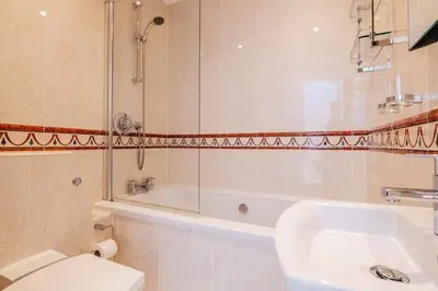 a bathroom with a toilet and a shower and a sink at The Penthouse Westhaven Aberdyfi in Aberdyfi