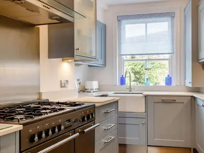 a kitchen with a stove and a sink at The Penthouse Westhaven Aberdyfi in Aberdyfi