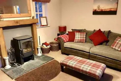 a living room with a couch and a fireplace at Quarry House in Presteigne