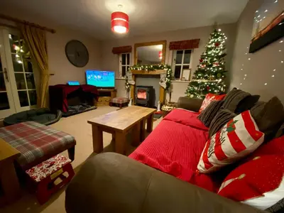 a living room with a christmas tree and a couch at Quarry House in Presteigne