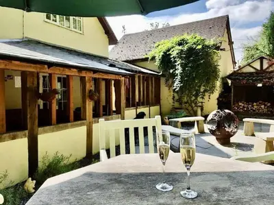 two glasses of wine on a table in front of a house at Quarry House in Presteigne