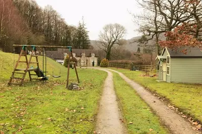 a dirt road with a playground in a yard at Quarry House in Presteigne
