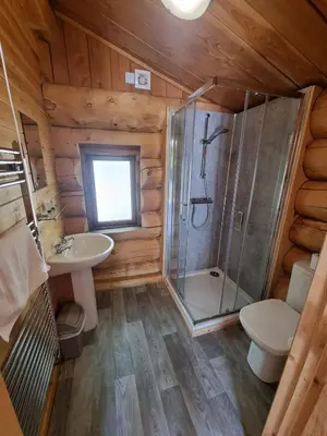 a bathroom with a shower and a toilet and a sink at Mountain Edge Resort Lodge 1 with Hot Tub in Church Stretton