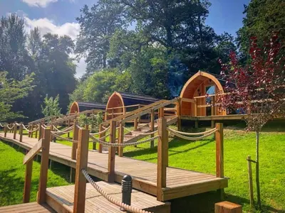 a wooden deck with a playground in the grass at Mountain Edge Resort Mega pod 1 with Hot Tub in Church Stretton