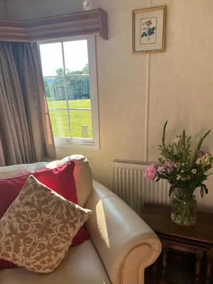 a living room with a couch and a vase of flowers at Heavenly Retreat in Lampeter
