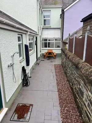 a patio outside of a house with a bench on it at Polruan - stunning central NQ house - dog friendly in New Quay