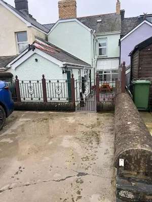 a house with a fence and a driveway at Polruan - stunning central NQ house - dog friendly in New Quay