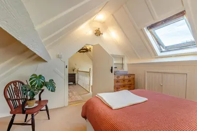 a attic bedroom with a bed and a skylight at Pandy Farmhouse - Panoramic mountain views within Snowdonia's National Park - 4x4 Only in Dolgellau
