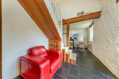 a red leather couch in a living room at Pandy Farmhouse - Panoramic mountain views within Snowdonia's National Park - 4x4 Only in Dolgellau