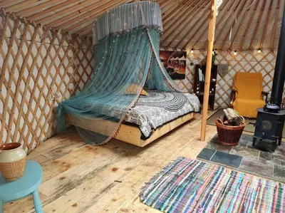 a bed in a yurt with a net in a room at Traditional Mongolian Yurt - Panoramic Mountain Retreat - 4x4 only in Dolgellau